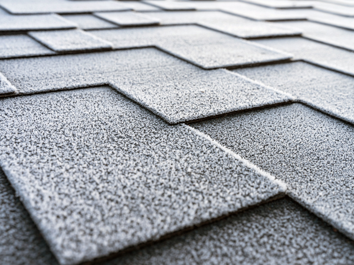 Close-up of textured gray asphalt shingles arranged in overlapping rows on a roof.